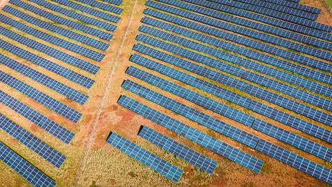 Aerial view of solar photovoltaic farm on green field. Stock Photos