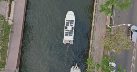 An aerial view of A Solar powered shuttle boat surfing on the canal at centra Stock Footage 266091078