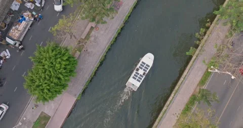 An aerial view of A Solar powered shuttle boat surfing on the canal at centra Stock Footage 274823270