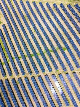 Aerial view of solar rows creating repeating geometric pattern across reclaim Foto stock