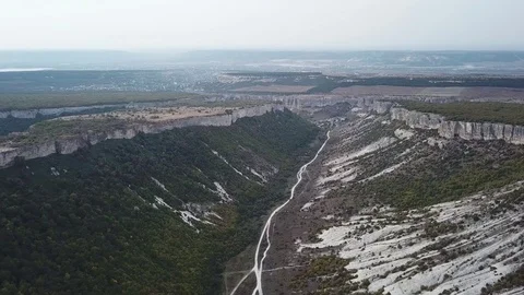 Aerial View: a span in the middle of a canyon, on one side of the cliff, on the Stock Footage 82679186