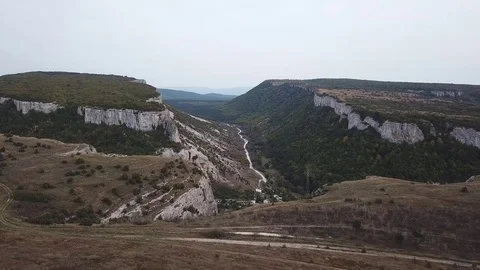 Aerial View: a span in the middle of a canyon, on one side of the cliff, on the Stock Footage 82681446