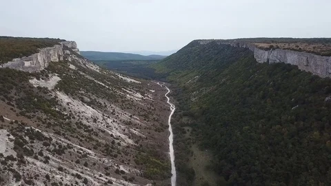 Aerial View: a span in the middle of a canyon, on one side of the cliff, on the Stock Footage 82683471