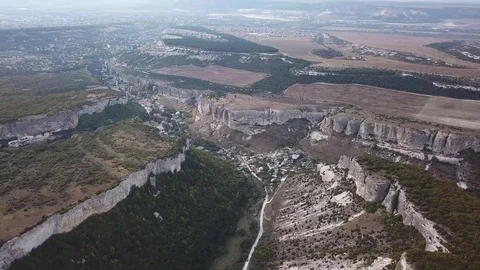 Aerial View: a span in the middle of a canyon, on one side of the cliff, on the Stock Footage 82689002