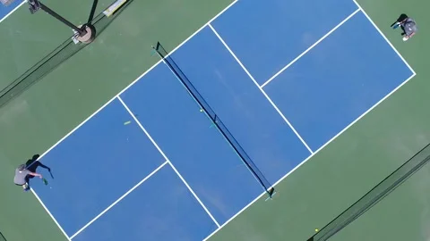 Aerial view with spiral of foursome playing pickleball outside Stock Footage