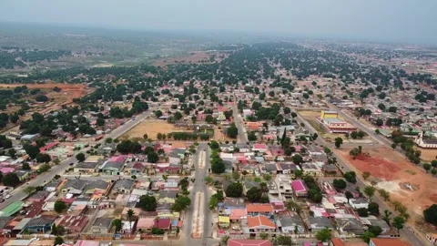 Aerial view of a sprawling town with dense tree cover and buildings under a Stock Footage 307897858