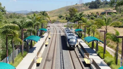 Aerial View of SPRINTER Train Departing El Camino Real Station in Oceanside Stock Footage 334620836