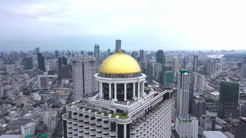 Aerial view of State Tower rising above Bangkok’s skyline, its golden dome and Stock Footage 331439219