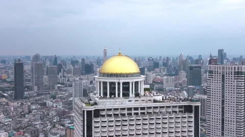Aerial view of State Tower rising above Bangkok’s skyline, its golden dome and Stock Footage 331439254