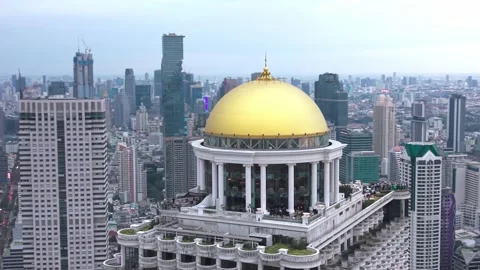 Aerial view of State Tower rising above Bangkok’s skyline, its golden dome and Stock Footage 331439269