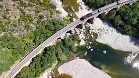 Aerial View of Steam Train Crossing Stone Railway Viaduct near Anduze, France Stock Footage 340348744