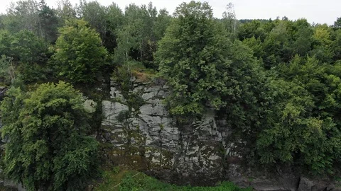 Aerial View of Steep Cliff on Rivers Edge With Thick Surrounded by Thick Stock Footage 124200130