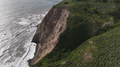 Aerial View of Steep Ocean Cliffs and Crashing Waves on a Rugged Coastline Video stock 331976692