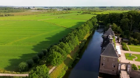 Aerial view of a stone castle surrounded by a moat, forest, and fields. Stock-Footage 317992312