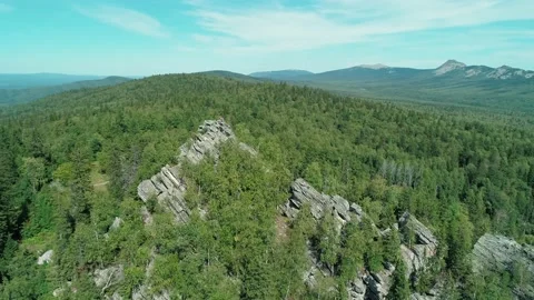 Aerial view of stone formations in the middle of a forest on bright sunny day Stock Footage 196220817