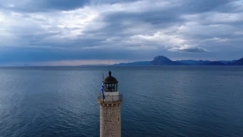 Aerial view of stone lighthouse by calm sea under overcast sky in summer Stock Footage 338108873