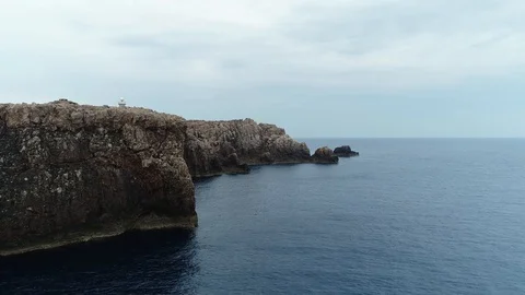 Aerial view of stone lighthouse  on the edge of a cliff Stock Footage 120641856