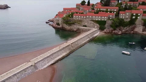 Aerial view of stone pier extending to Mediterranean village on rocky coast Stock-Footage 342748067