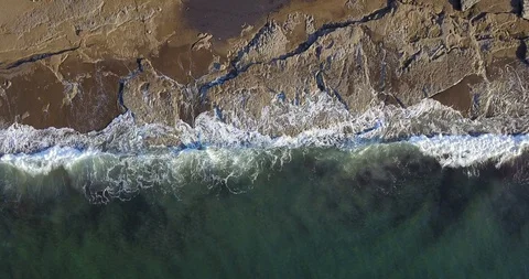 Aerial view of a stony coastal section with approaching breaking waves and spray Video stock 123405921