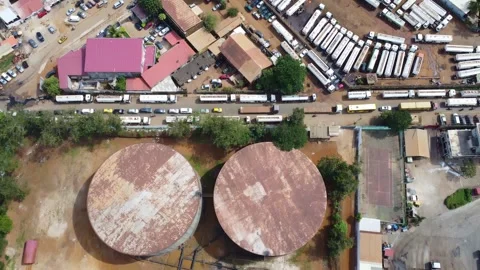 Aerial view of storage tanks with rust on the roof, surrounded by greenery and Stock Footage 317455750