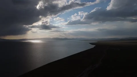 Aerial view of storm clouds and sun glitter over Song-Kol lake, Kyrgyzstan Stockbeeldmateriaal 347240377