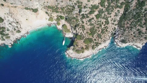 Aerial view of stunning a sun-kissed blue lagoon where a sailing yacht Stock Footage 246051753