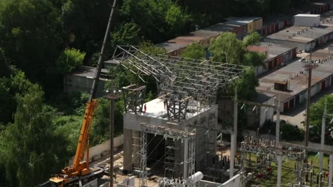 Aerial view of substation construction with crane holding metal structure Stock Footage 339794841