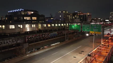 Aerial view of a subway train passing through Brooklyn, New York City at night 스톡 동영상 251925710