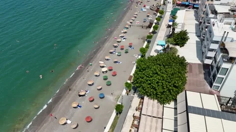 Aerial view of summer beach umbrellas and lounge chairs by the beach Stock Footage 336623692