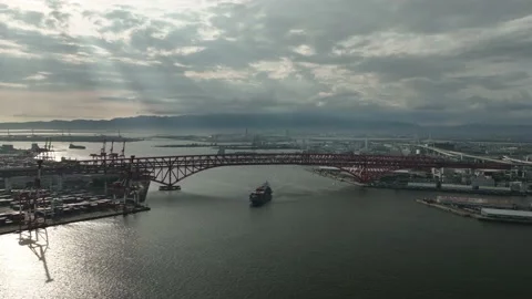 Aerial view as sun rays shine though cloud on container ship entering port Video stock 201173123