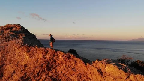 Aerial view sun sets in pink sky above cliffs and blue sea Video stock 103836608