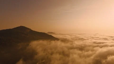 Aerial view of the sun setting behind mountains Stock Footage 302265083