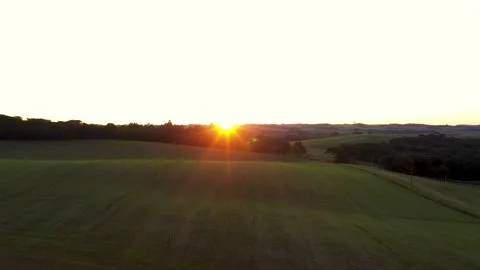 Aerial view of sun setting over rolling green fields in Brazil Stock Footage 329176281