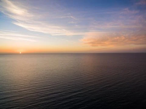 Aerial view of sun setting over ocean. Nothing but skies and water. Beautifu  Stockfoto's