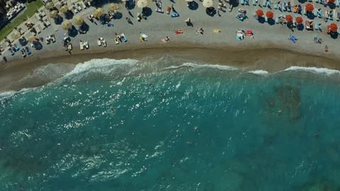 Aerial view: sun umbrellas stand on pebble beach. Sea resort and rest. Rhodes 스톡 동영상 118888198