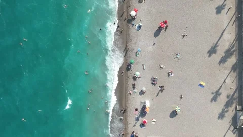 Aerial view of sunbathing people at the beach with colorful beach umbrellas Stock Footage 343711026