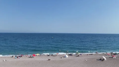 Aerial view of sunbathing people at the beach with colorful beach umbrellas Stock Footage 343716230