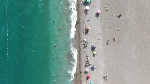 Aerial view of sunbathing people at the beach by turquoise sea Stock Footage 343856437