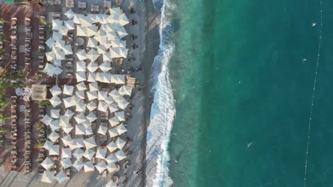 Aerial view of sunbathing people at the beach with beach umbrellas Stock Footage 344356675