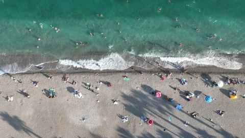 Aerial view of sunbathing people at the beach with colorful beach umbrellas Vídeos de archivo 346610377