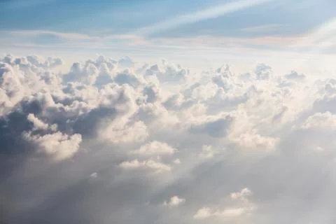 Aerial view sunbeams over fluffy white clouds Stock Photos