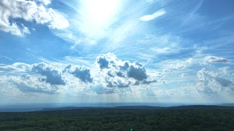 Aerial View of Sunbeams Piercing Dramatic Clouds Over Lush Green Forest Stock Footage 340009734