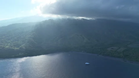 Aerial View of Sunlight Shining Through Clouds Over Volcanic Island Stock Footage 248239936