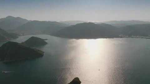 Aerial View of Sunlit Bay Surrounded by Mountains Stock Footage 282931138