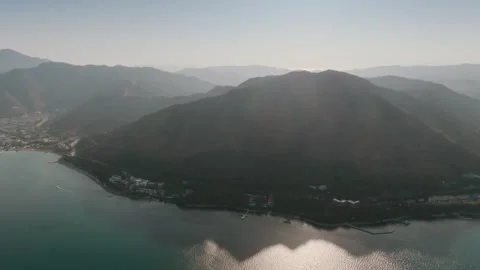 Aerial View of Sunlit Bay Surrounded by Mountains Stock Footage 282931145