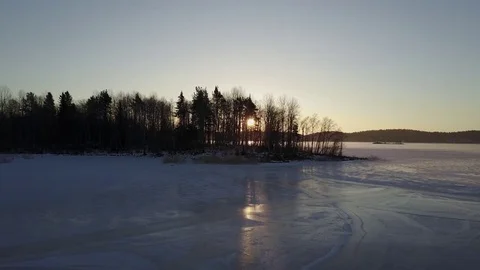 Aerial view: The sunrays of the rising sun shines through the trees, Ladoga Lake Stock Footage 71252352