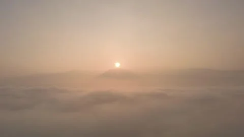 Aerial View of Sunrise Above the Clouds and Mountain Silhouette Stock Footage 335216852