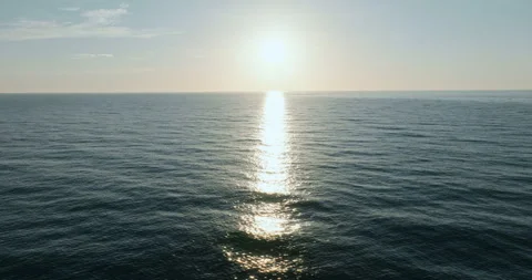 Aerial view sunrise over open sea sun casting golden light Stock-Footage 303317357