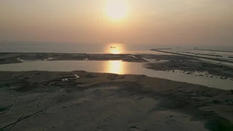 Aerial view of sunset at the beach with a cargo ship in the sea  Stock Footage 273629724