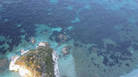 Aerial view at sunset crystal clear blue water and seagulls flying one the sea Stock Footage 85362580